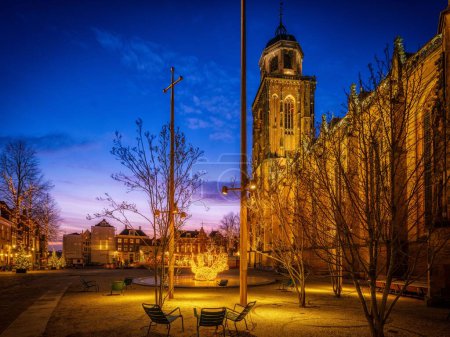 Téléchargez les photos : Une belle vue sur les lumières sur la vieille place de l'église à Deventer pendant la nuit tombée aux Pays-Bas - en image libre de droit