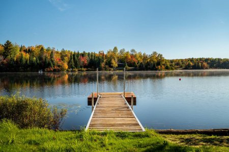 Photo for A dock and the autumn trees reflecting on lac Fairburn, Quebec - Royalty Free Image