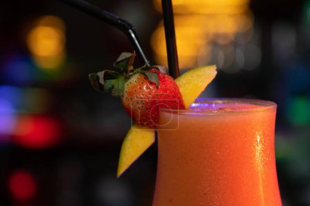 Photo for A cocktail on a bar decorated with strawberry and mango - Royalty Free Image