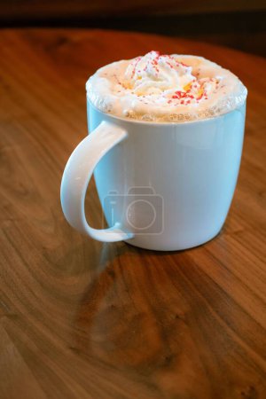 Photo for A vertical shot of a toasted white chocolate mocha with whipped cream on a wooden table - Royalty Free Image
