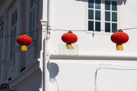 Téléchargez les photos : Une ligne de lanternes en papier rouge vif décorant l'extérieur d'un bâtiment pendant le Nouvel An chinois - en image libre de droit