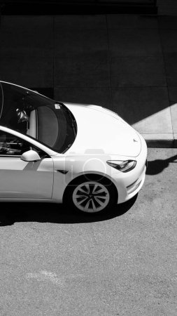 Foto de Una vista superior vertical de un coche Tesla blanco moderno modelo 3 estacionado en la calle en Portland - Imagen libre de derechos
