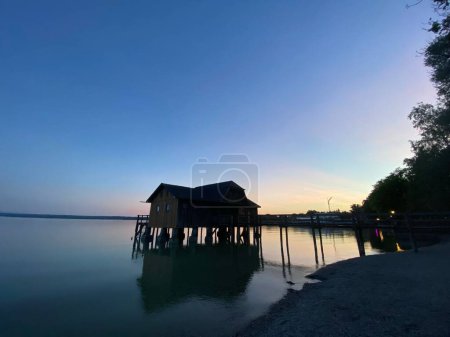 Photo for A beautiful shot of an overwater bungalow on stilts, during the blue-hour - Royalty Free Image
