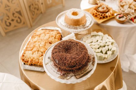 Téléchargez les photos : Un gros plan de gâteau au chocolat avec saupoudrer servi avec d'autres pâtisseries à un banquet - en image libre de droit