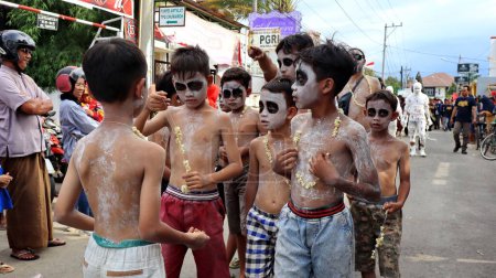 Foto de Un primer plano de niños varones con caras de miedo pintadas durante un festival callejero, Indonesia - Imagen libre de derechos