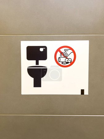 Foto de Una toma vertical del letrero del inodoro con el símbolo prohibido de la basura en la pared - Imagen libre de derechos