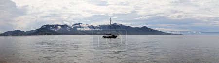 Téléchargez les photos : Un petit navire à la surface d'une mer près de la côte de l'île d'Ilhabella au Brésil - en image libre de droit