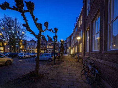 Téléchargez les photos : L'extérieur du bâtiment EICAS à Deventer pendant l'heure bleue et les voitures garées avec vélo devant, aux Pays-Bas - en image libre de droit
