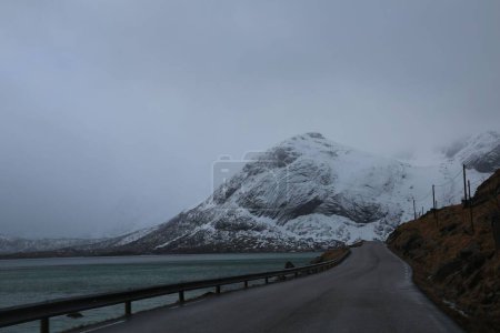 Téléchargez les photos : Une belle vue sur une route au bord du lac et une montagne enneigée en arrière-plan - en image libre de droit