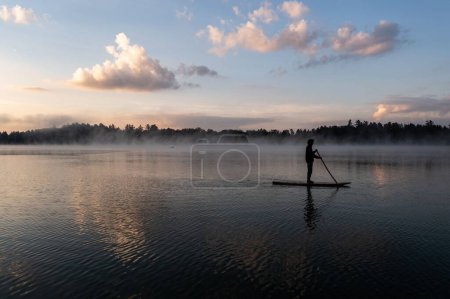 Photo for A beautiful view of a man on a puddle board on a sunset scene background - Royalty Free Image