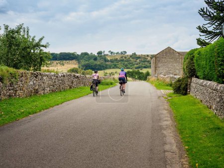 Téléchargez les photos : Un beau cliché de deux cyclistes chevauchant une voie de campagne dans le Derbyshire, Royaume-Uni - en image libre de droit