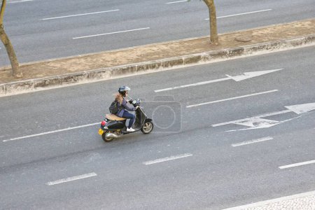 Téléchargez les photos : Une motard en scooter motorisé dans les rues de Lisbonne - en image libre de droit