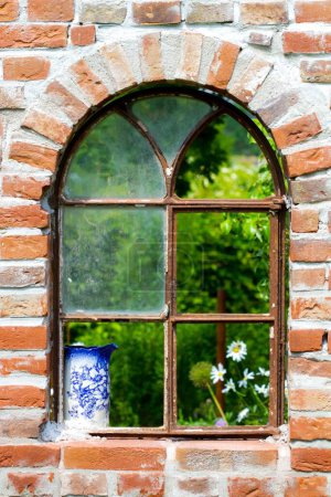 Foto de Una vieja ventana en la pared de piedra en el jardín - Imagen libre de derechos