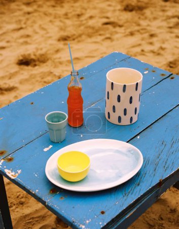 Téléchargez les photos : Un plan vertical de boisson et de vaisselle sur une table en bois bleu - en image libre de droit