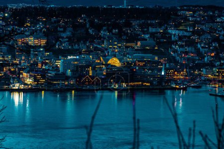 Téléchargez les photos : Une vue imprenable sur le paysage urbain, le soir, avec une réflexion des lumières de la ville à la surface de l'eau - en image libre de droit