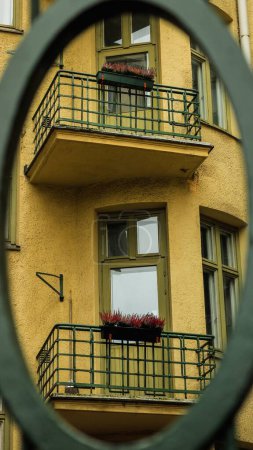 Téléchargez les photos : Plan vertical d'un immeuble résidentiel à parois jaunes avec un objet rond au premier plan - en image libre de droit