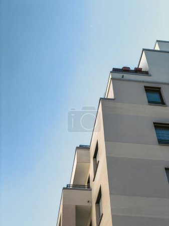 Téléchargez les photos : Vue en angle bas d'un immeuble résidentiel contre un ciel bleu vif - en image libre de droit