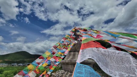 Téléchargez les photos : Un gros plan de drapeaux de prière tibétains colorés avec le paysage de Shangri La en arrière-plan en Chine - en image libre de droit
