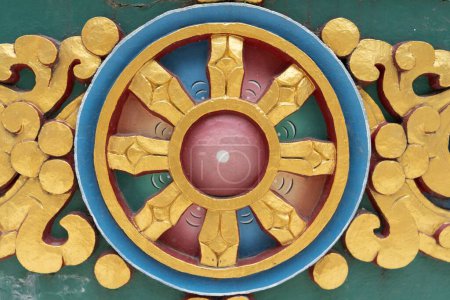 Photo for A closeup of a round Buddhist Dharma Wheel in golden blue and red colors - Royalty Free Image