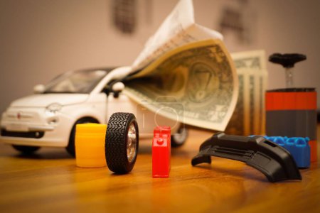 Téléchargez les photos : Une voiture miniature remplie de billets de banque représentant les frais de voiture - en image libre de droit