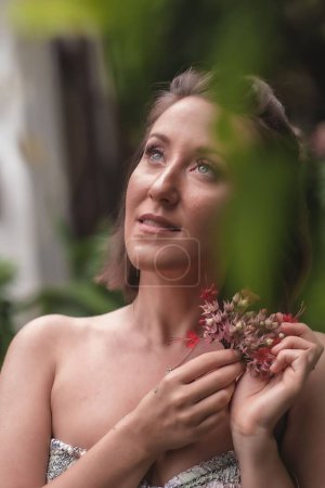 Téléchargez les photos : Un gros plan vertical d'une belle femme tenant des fleurs sauvages. - en image libre de droit