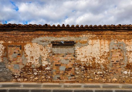 Téléchargez les photos : Vue panoramique d'un vieux mur rustique d'une maison sous un ciel nuageux - en image libre de droit