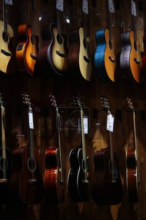 Téléchargez les photos : Une collection de guitares acoustiques exposées dans le magasin. - en image libre de droit