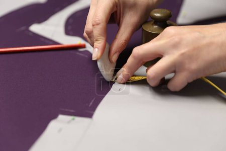 Photo for A closeup shot of a young female designer taking measurements for making a dress - Royalty Free Image
