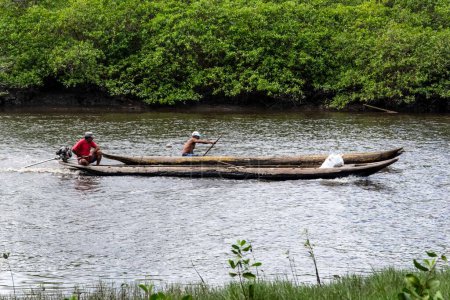Téléchargez les photos : Deux pêcheurs, chacun en canot, naviguant sur la rivière Jaguaripe, ville d'Aratuipe, en plein soleil matinal. - en image libre de droit