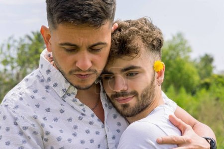 Foto de Un primer plano de una pareja gay hispana abrazada al aire libre. - Imagen libre de derechos