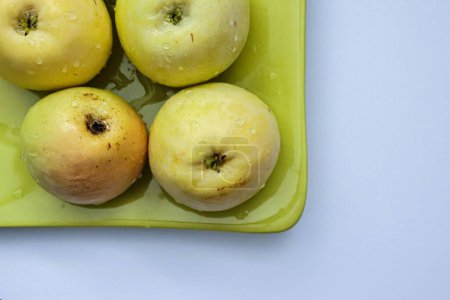 Téléchargez les photos : Une vue de dessus des pommes vertes des espèces pero bravo esmolfe lavées à l'eau douce sur une assiette verte - en image libre de droit