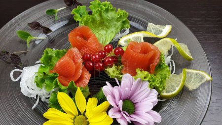 Téléchargez les photos : Une vue de dessus d'une assiette de saumon avec des légumes et des décorations de fleurs servis dans un restaurant japonais - en image libre de droit