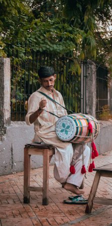 Photo for A Man Sitting and playing the drum Peacefully in the streets of Karachi - Royalty Free Image