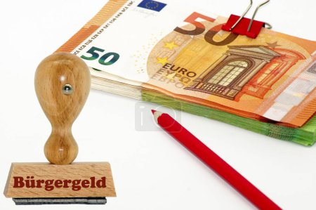 Téléchargez les photos : Un timbre en caoutchouc en bois avec billets d'euros et crayon rouge en arrière-plan - en image libre de droit