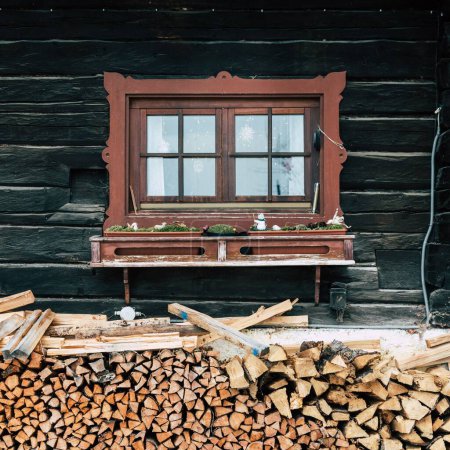 Foto de Una ventana de una casa de madera con una pila de madera debajo. - Imagen libre de derechos