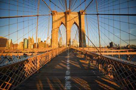 Téléchargez les photos : Une vue diurne du pont de Brooklyn tôt le matin avec du soleil dessus à New York - en image libre de droit