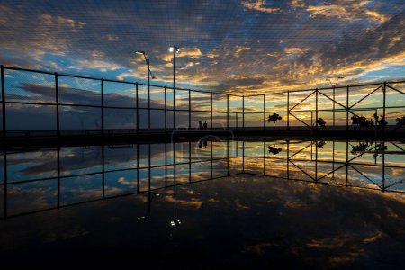 Téléchargez les photos : Salvador, Bahia, Brésil - décembre 05, 2021 : Les gens qui font de l'exercice sur le bord de la plage de Rio Vermelho à Salvador, Bahia, contre le coucher du soleil bleu. - en image libre de droit