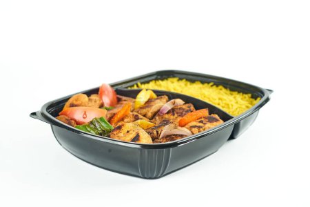 Téléchargez les photos : Gros plan de viande grillée et de riz dans un récipient en plastique noir sur fond blanc - en image libre de droit