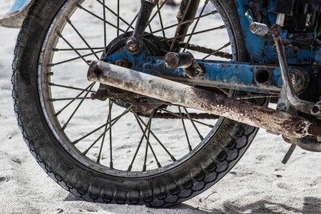 Foto de Rueda de una motocicleta oxidada en la playa en México - Imagen libre de derechos
