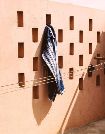 Foto de Un plano vertical de una toalla de playa mojada colgada en la pared - Imagen libre de derechos