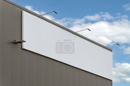 Photo for A big blank billboard on a gray building with the bright cloudy sky in the background - Royalty Free Image