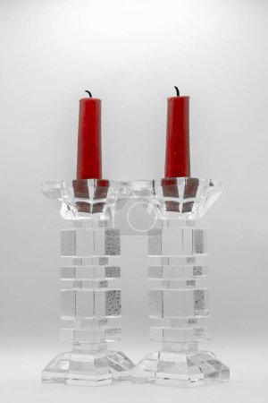 Foto de Un primer plano de dos velas rojas en candelabros de vidrio transparente - Imagen libre de derechos