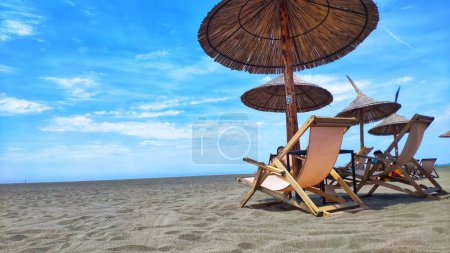 Foto de Las sombrillas y tumbonas en la orilla en un día soleado - Imagen libre de derechos