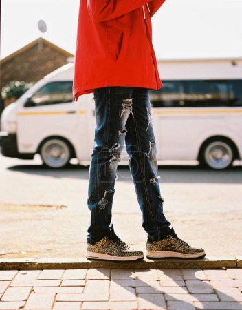 Photo for A vertical shot of a cool kid walking in the street in Johannesburg, South Africa - Royalty Free Image