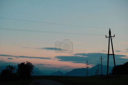Téléchargez les photos : Les poteaux électriques contre un coucher de soleil - en image libre de droit