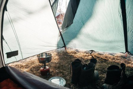 Téléchargez les photos : Deux paires de bottes et un brûleur à gaz dans une tente - en image libre de droit