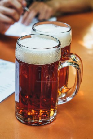 Photo for A vertical shot of two mugs of beer - Royalty Free Image