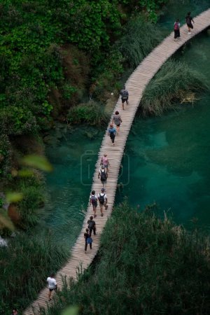 Téléchargez les photos : Vue aérienne verticale de personnes traversant un pont dans le célèbre parc national des lacs de Plitvice en Croatie - en image libre de droit