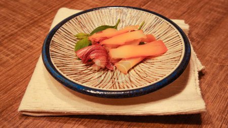 Téléchargez les photos : Assiette de plat frais avec calmar grillé sur un tissu sur une table en bois - en image libre de droit