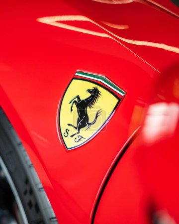 Téléchargez les photos : Un plan vertical grand angle de l'insigne du logo Ferrari sur la voiture rouge - en image libre de droit